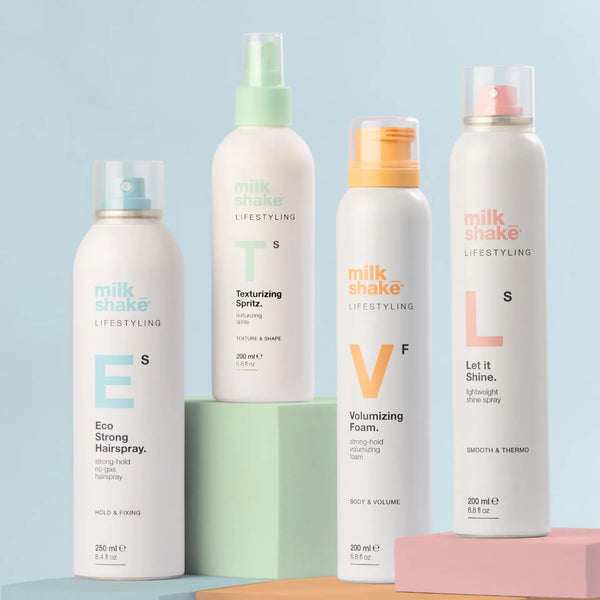 Set of milk_shake hair care products on colorful stands against a light blue background